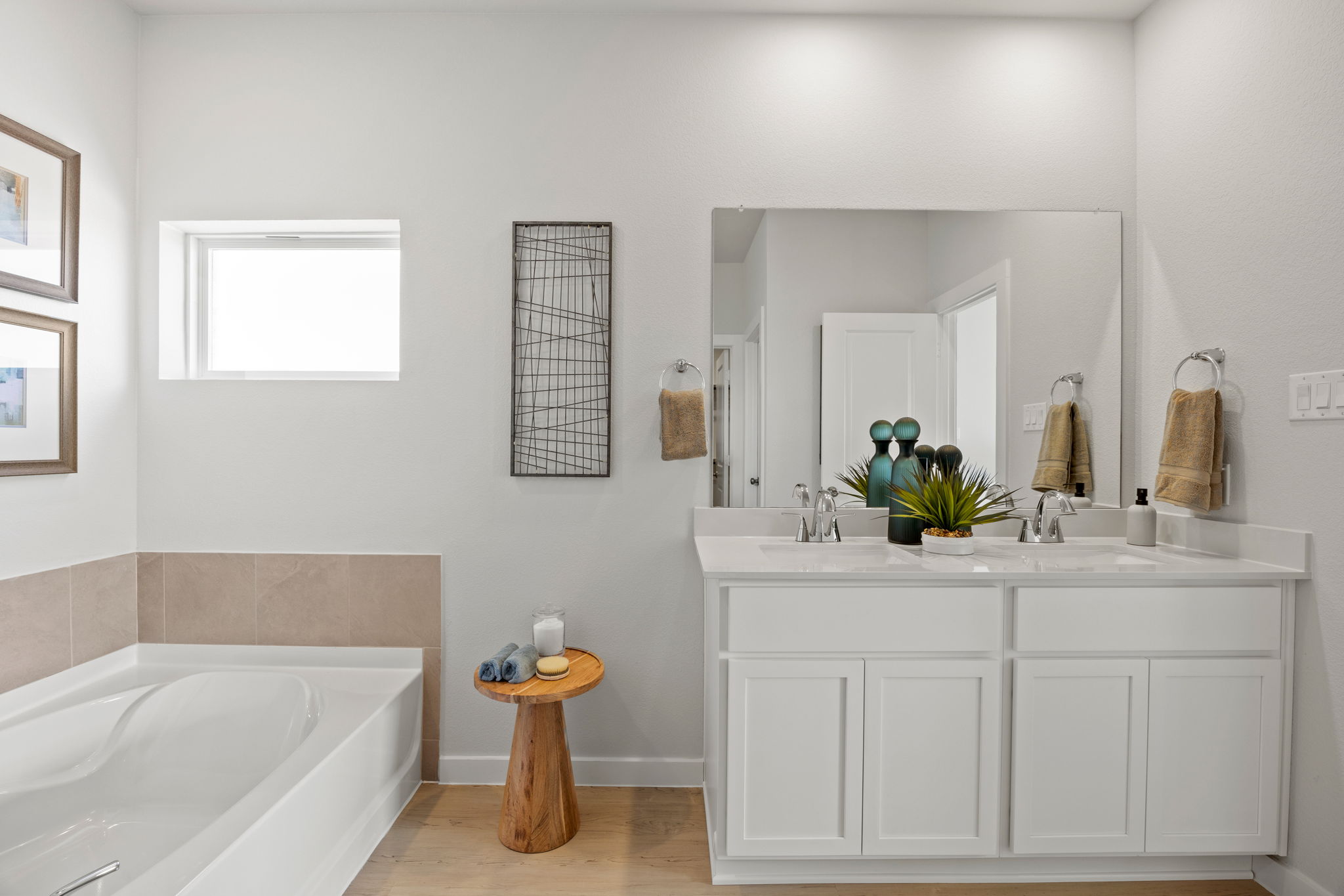 A bathroom with a tub sink and mirror.