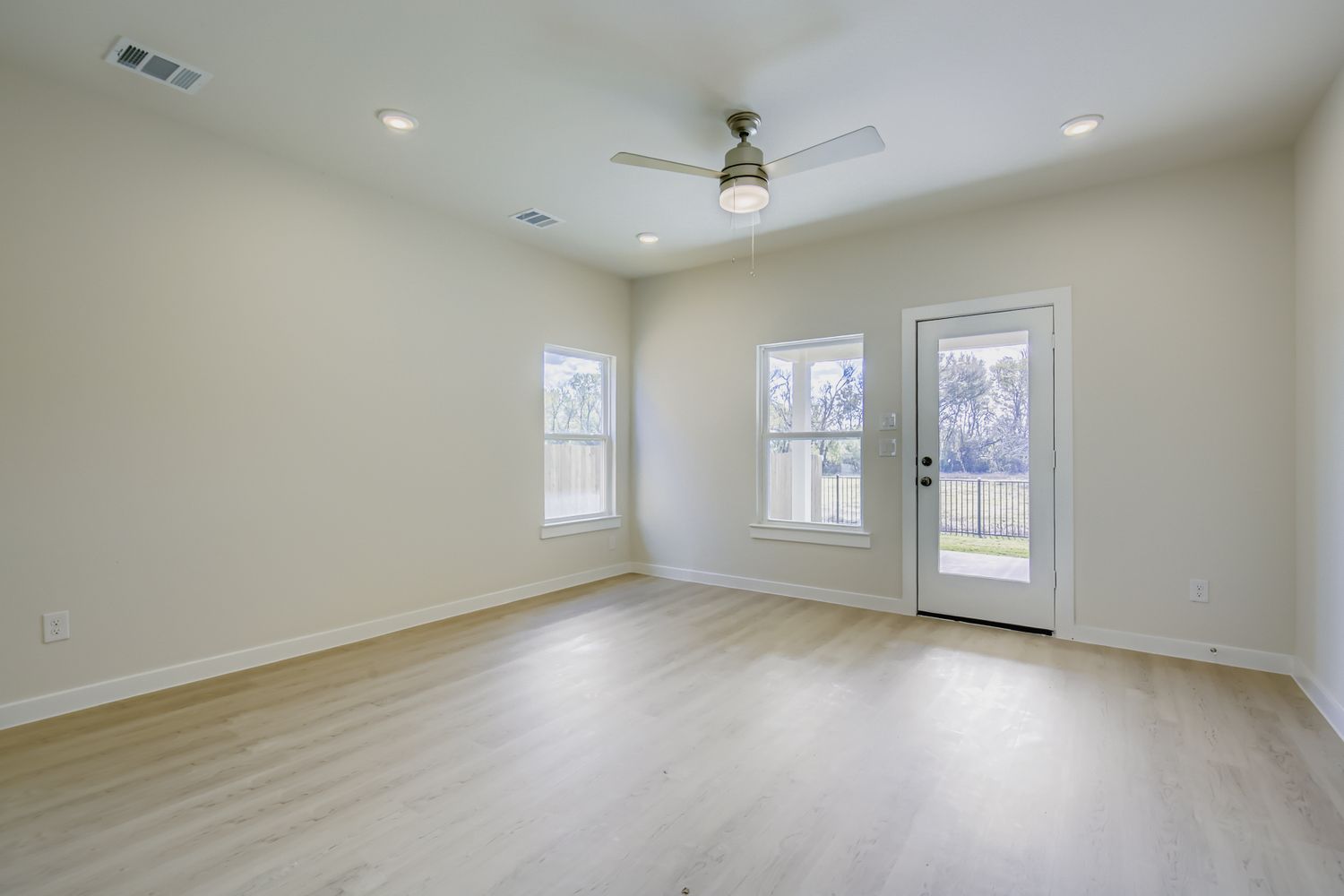 A room with a wood floor and a ceiling fan.