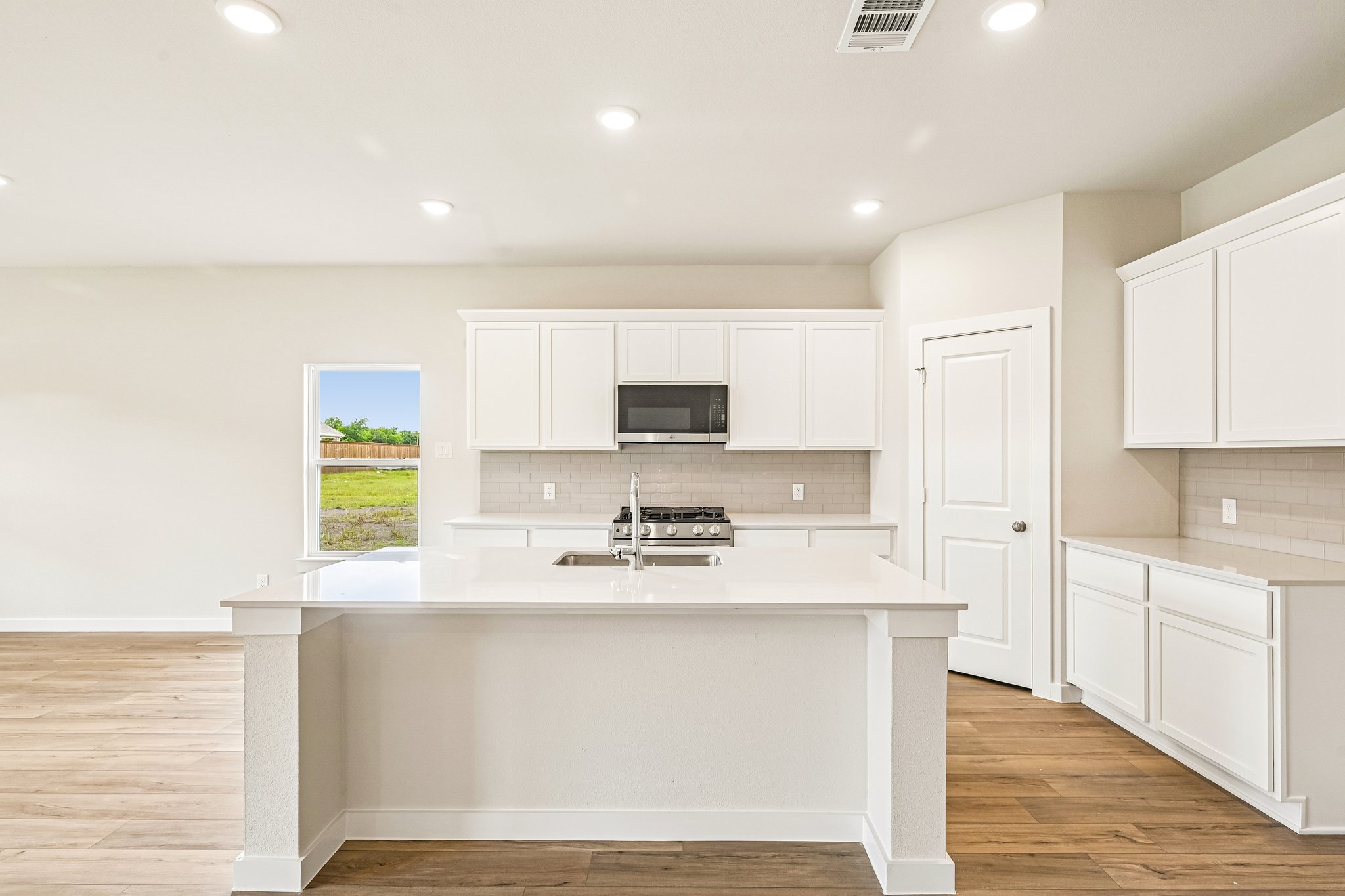 A kitchen with white cabinets.