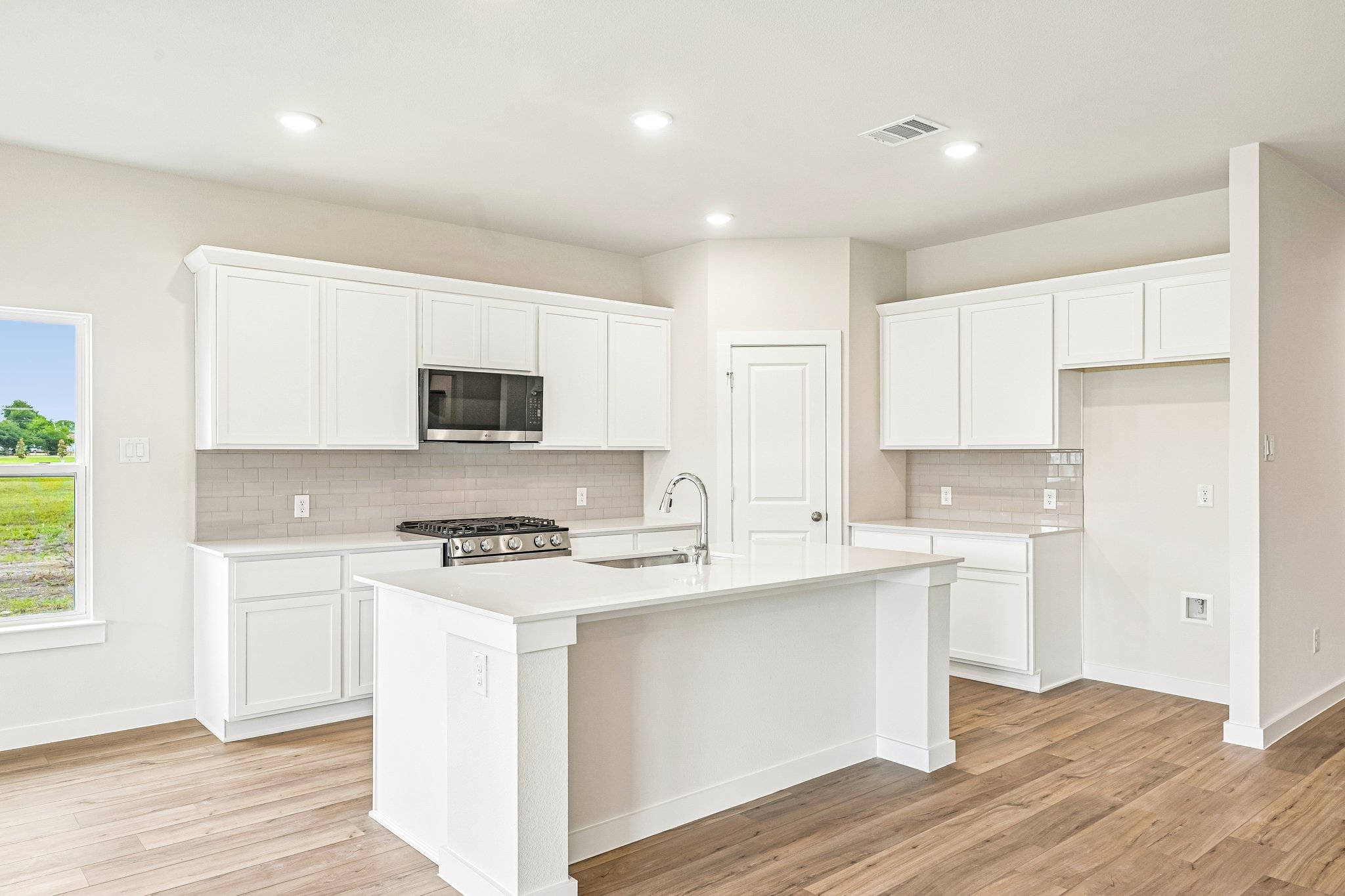 A kitchen with white cabinets.