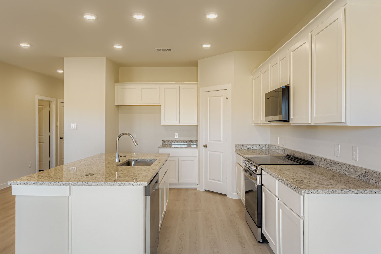 A kitchen with white cabinets.