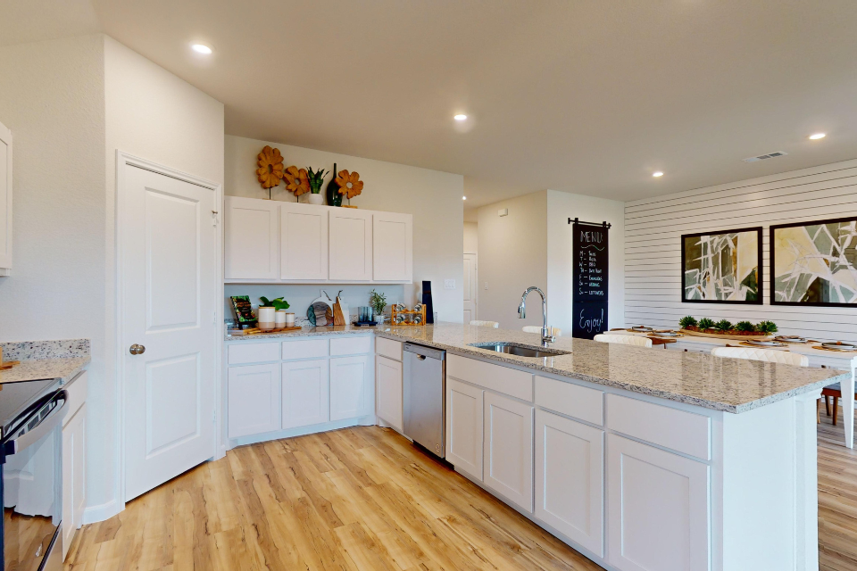 A kitchen with white cabinets.