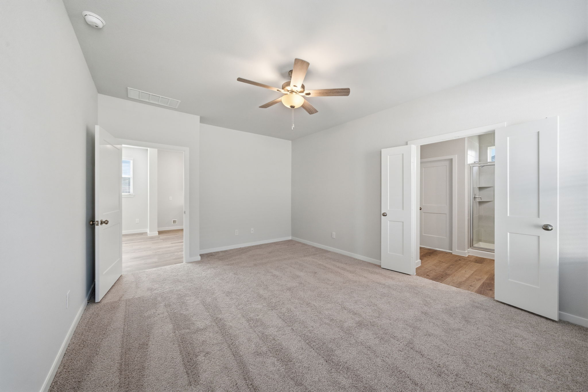 A room with white doors and a ceiling fan.