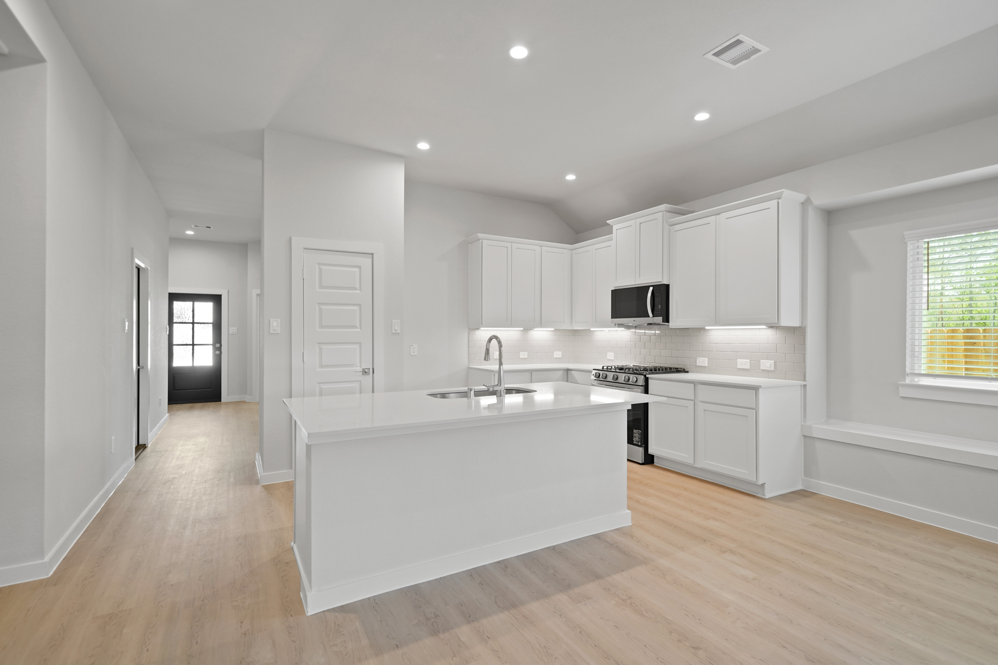 A kitchen with white cabinets.