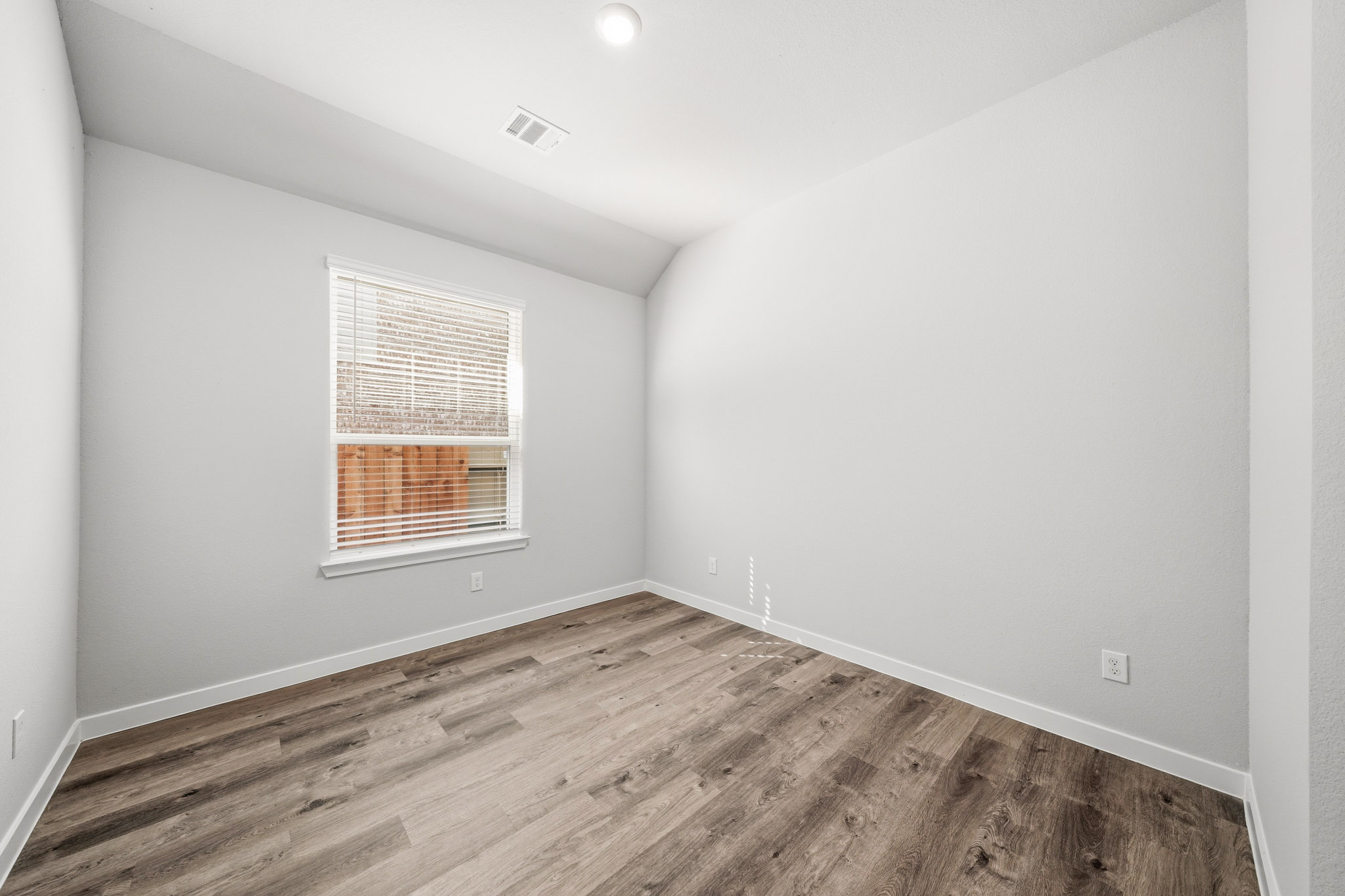 A room with a wood floor and a window.