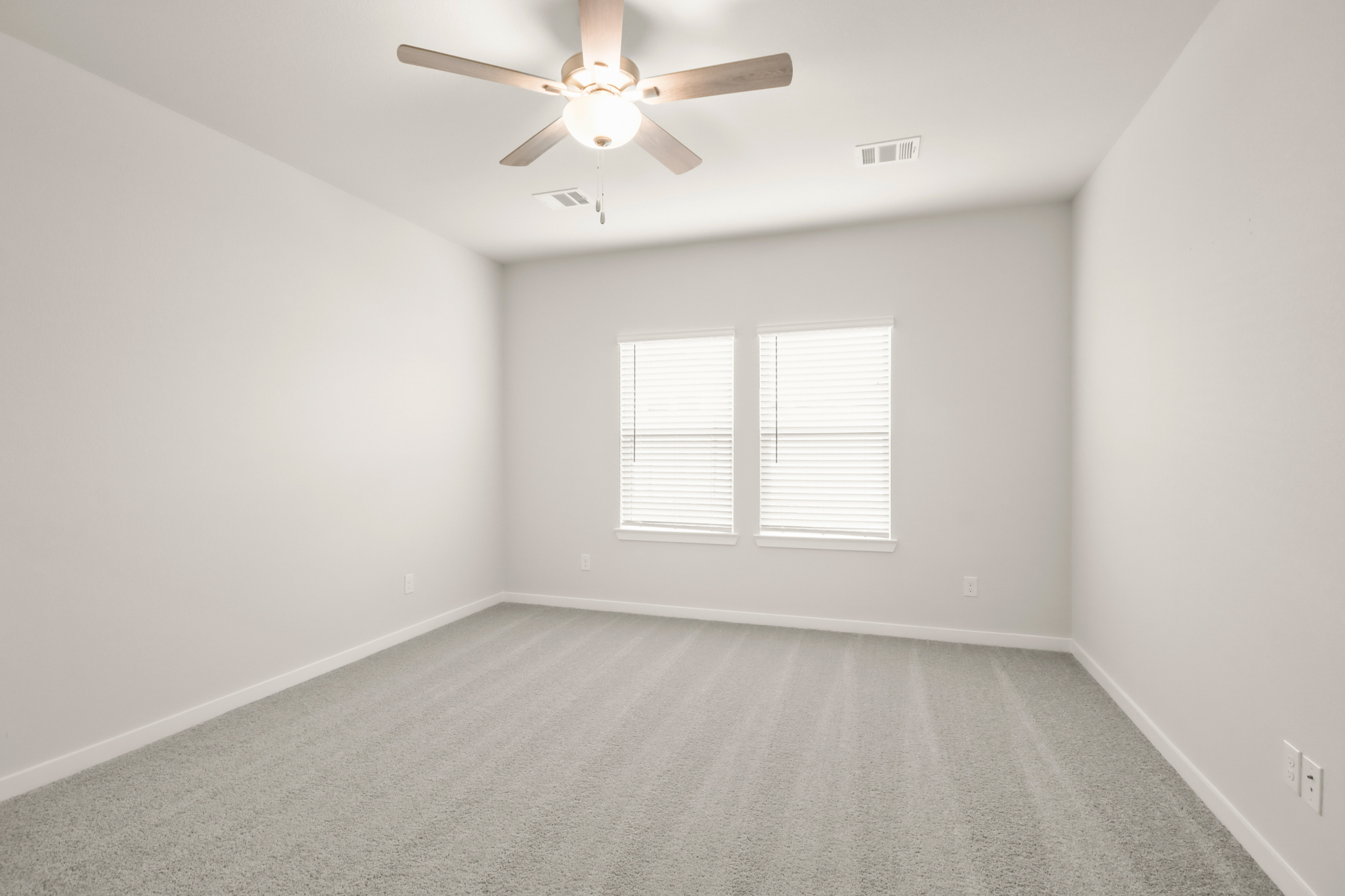 A room with a ceiling fan and a window.