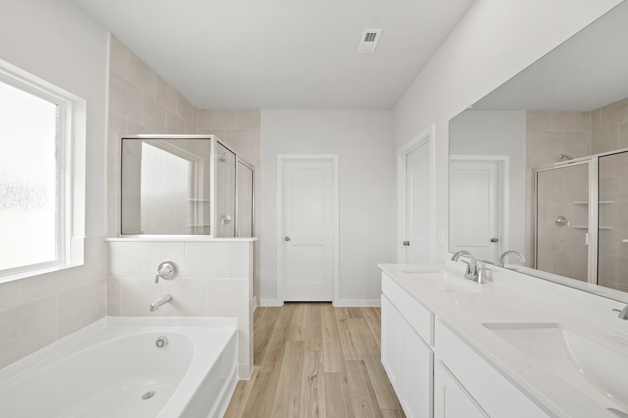 A bathroom with a tub sink and mirror.