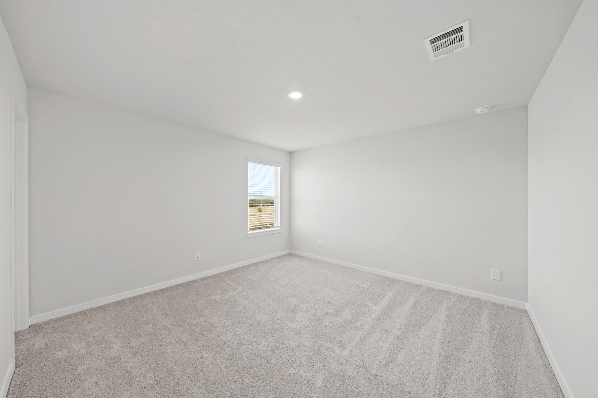 A room with a carpet and a window.