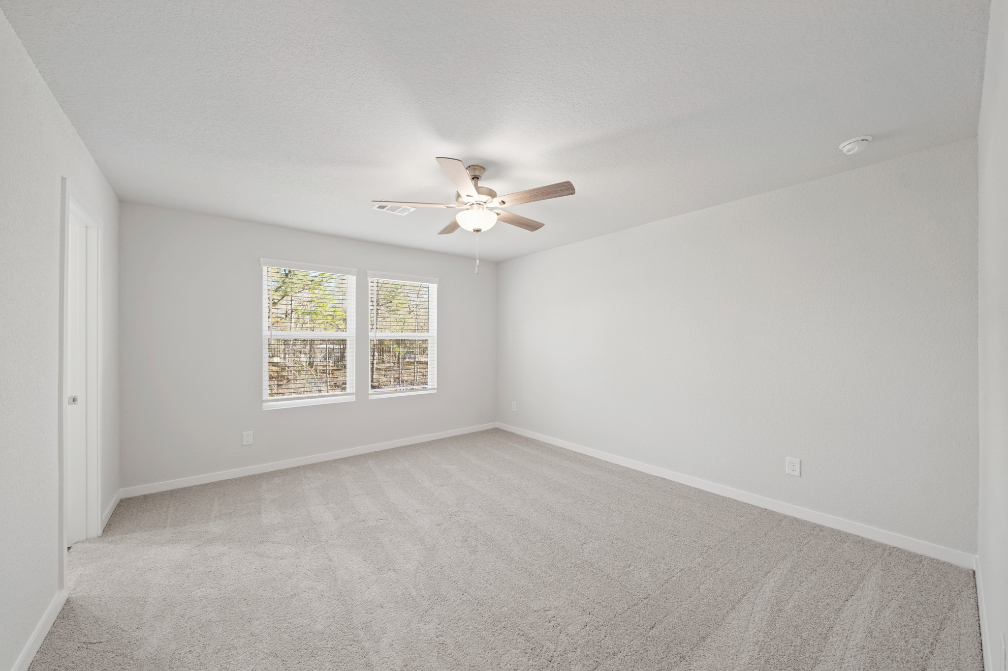 A room with a ceiling fan and a window.
