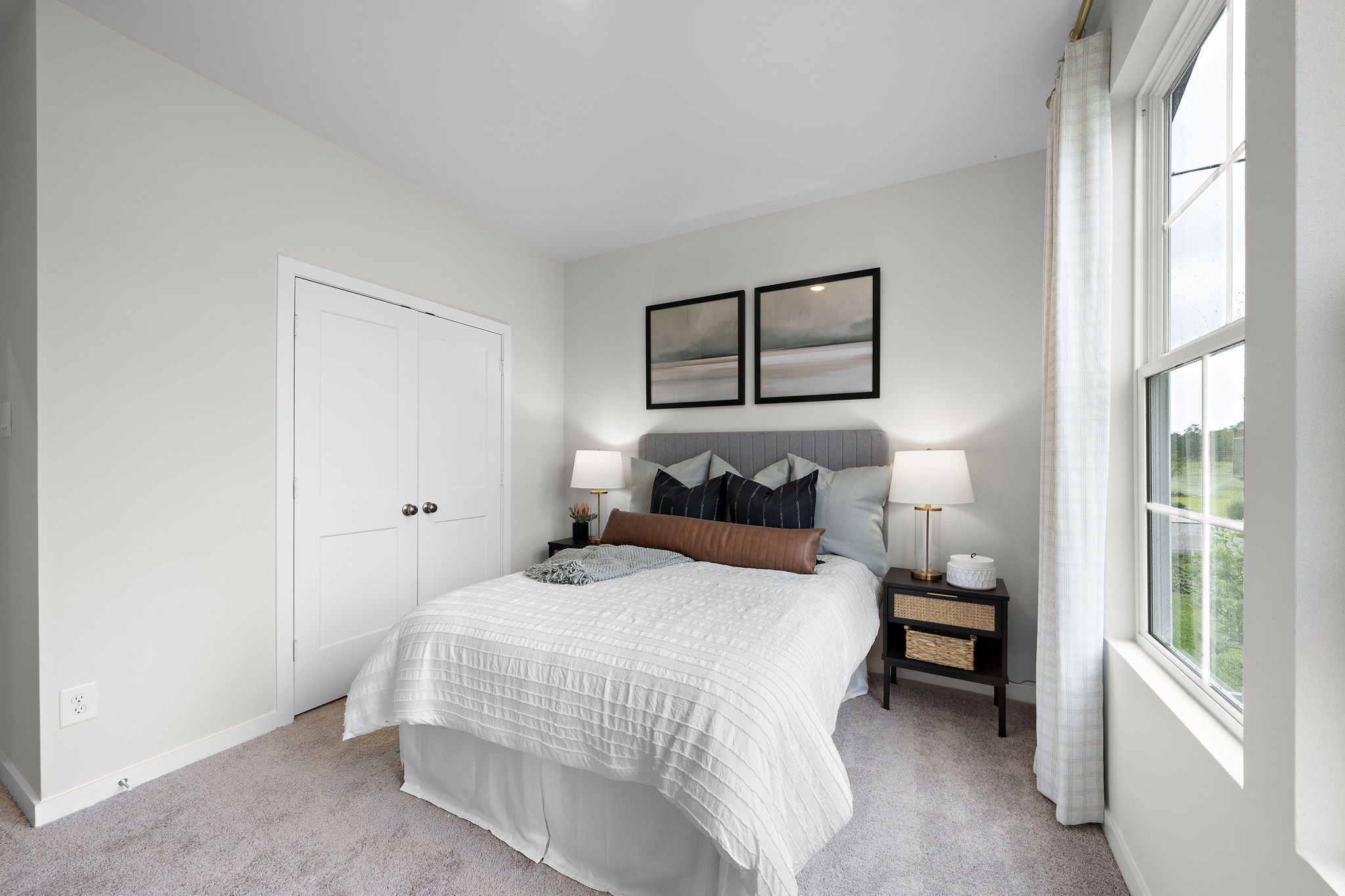 A bedroom with a bed and lamps.