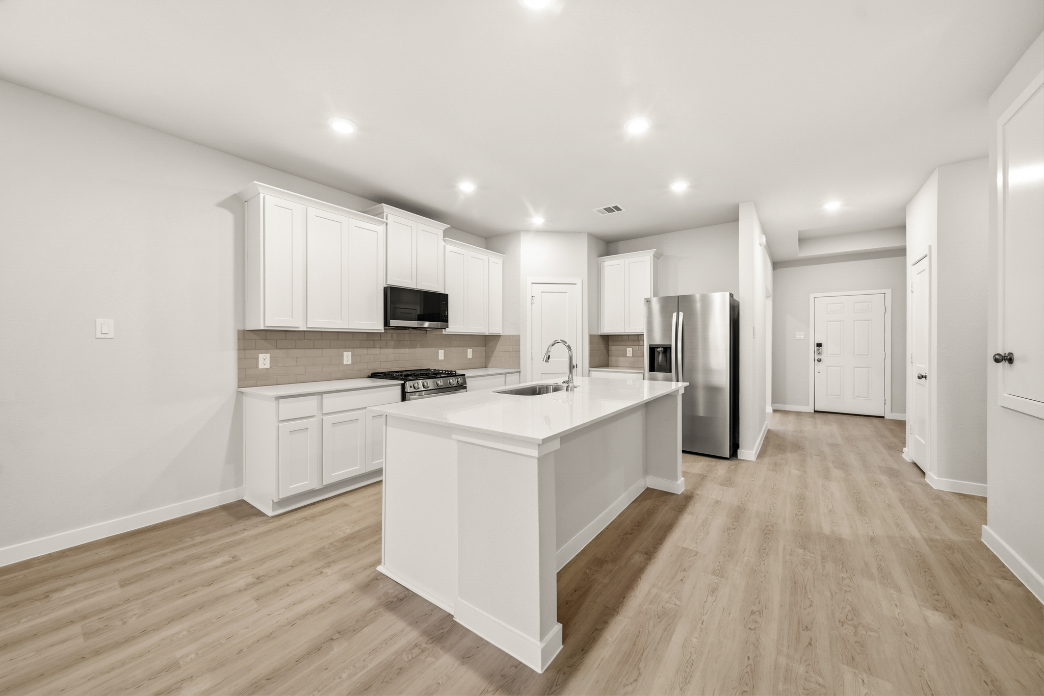 A kitchen with white cabinets.
