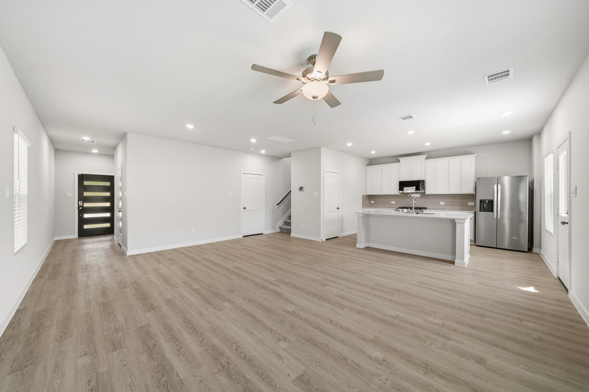 A large kitchen with a wood floor.