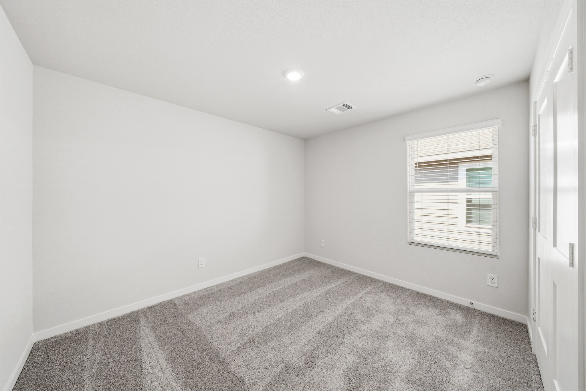A room with a carpet and a window.