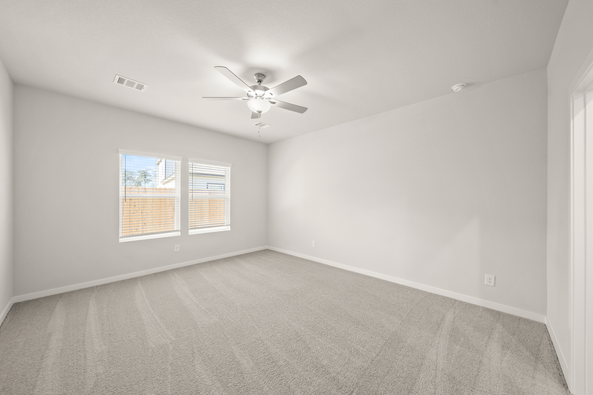 A room with a ceiling fan and a window.
