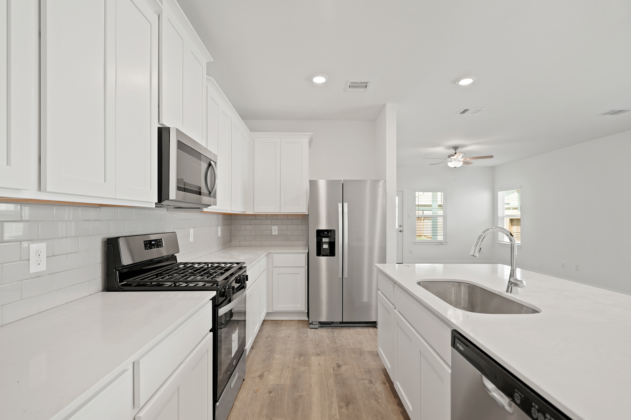 A kitchen with white cabinets.