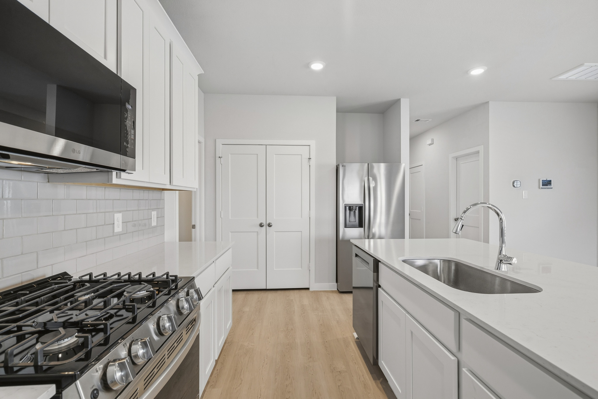 A kitchen with white cabinets.