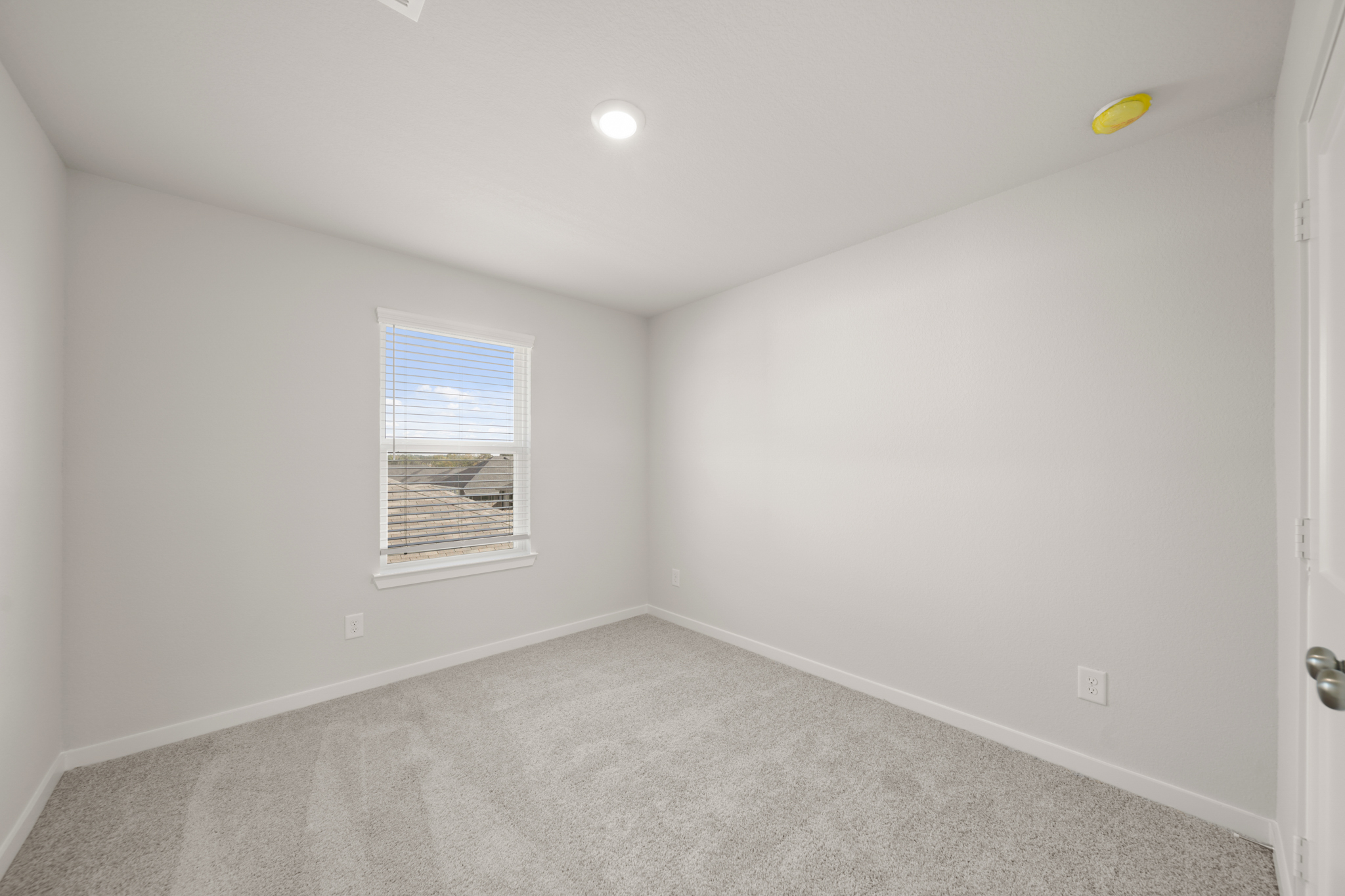 A room with a carpet and a window.