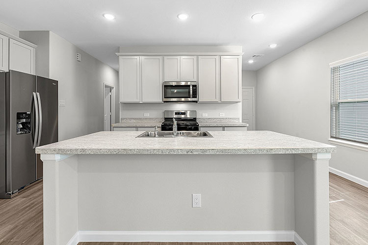 A kitchen with white cabinets.