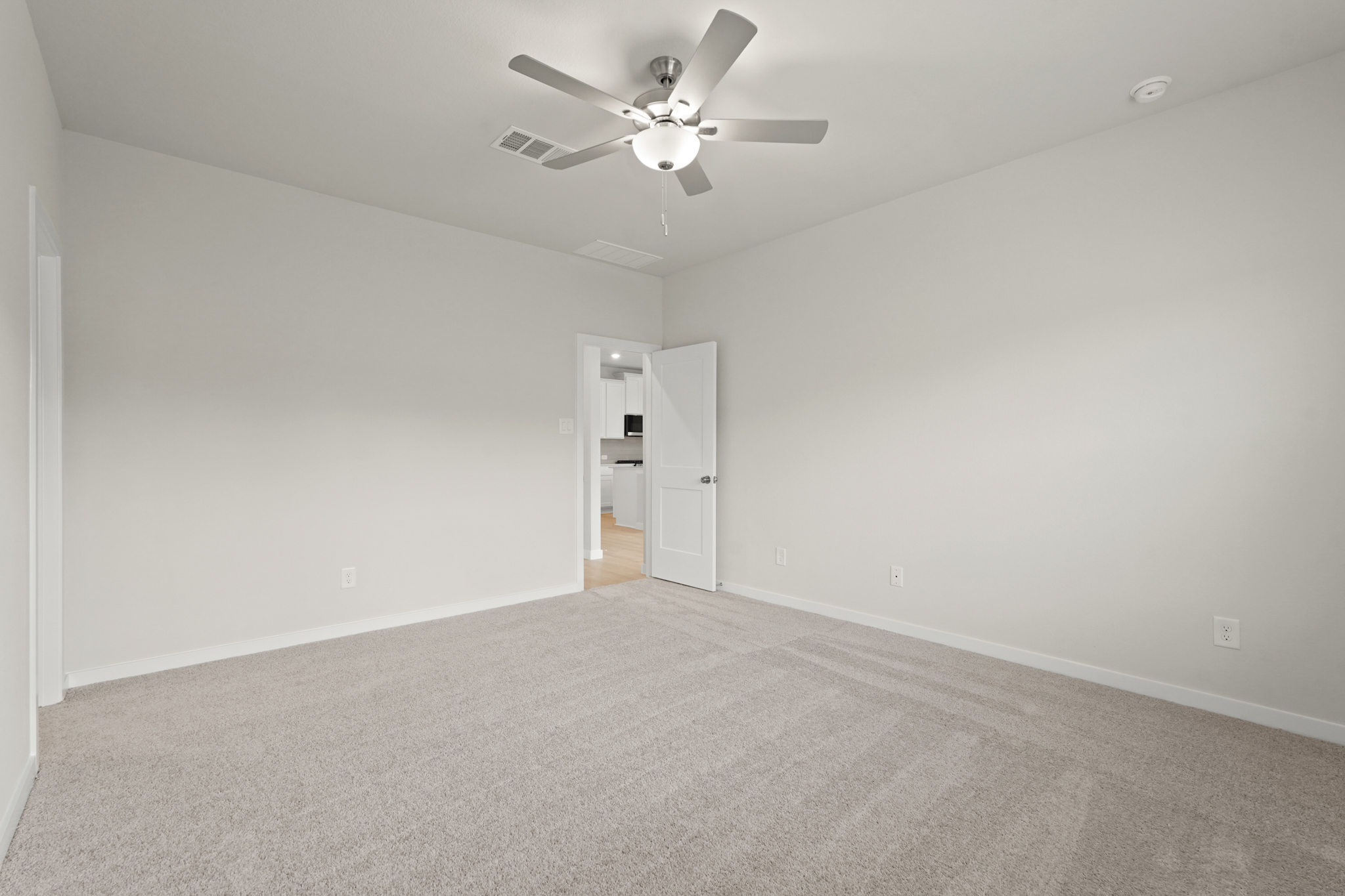 A room with a ceiling fan and a door.