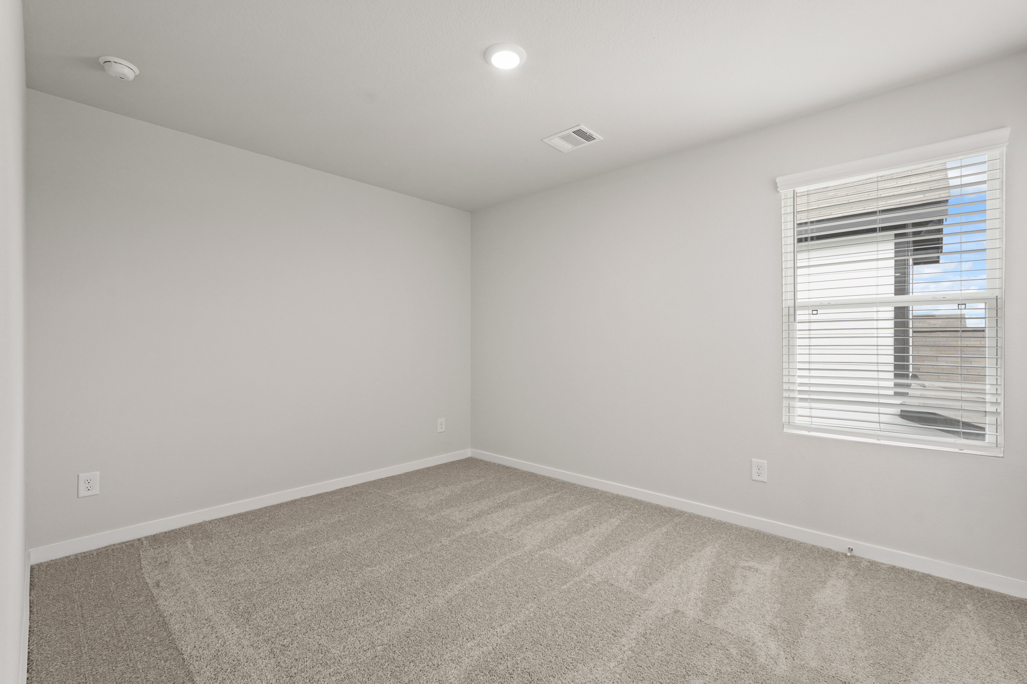 A room with a window and a carpet.