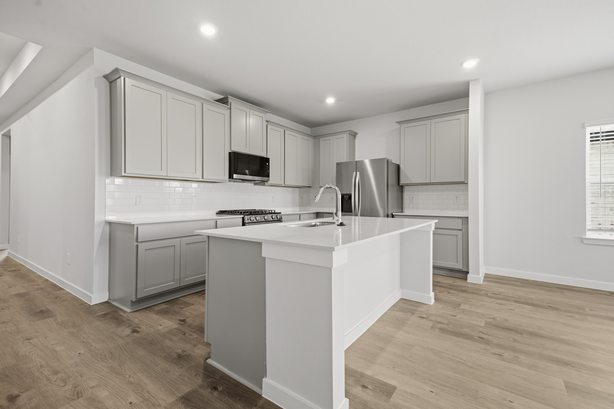 A kitchen with white cabinets.