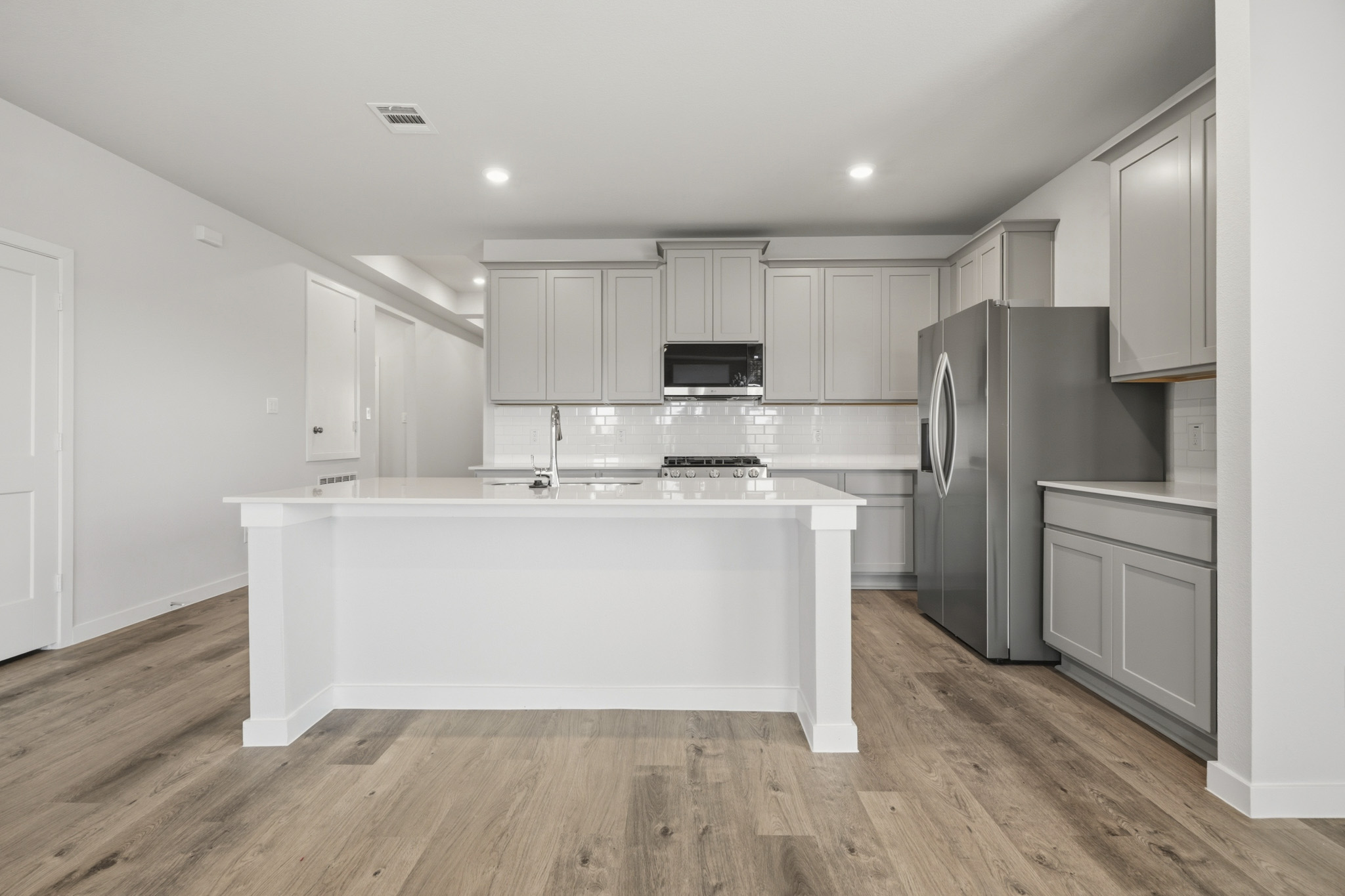 A kitchen with white cabinets.
