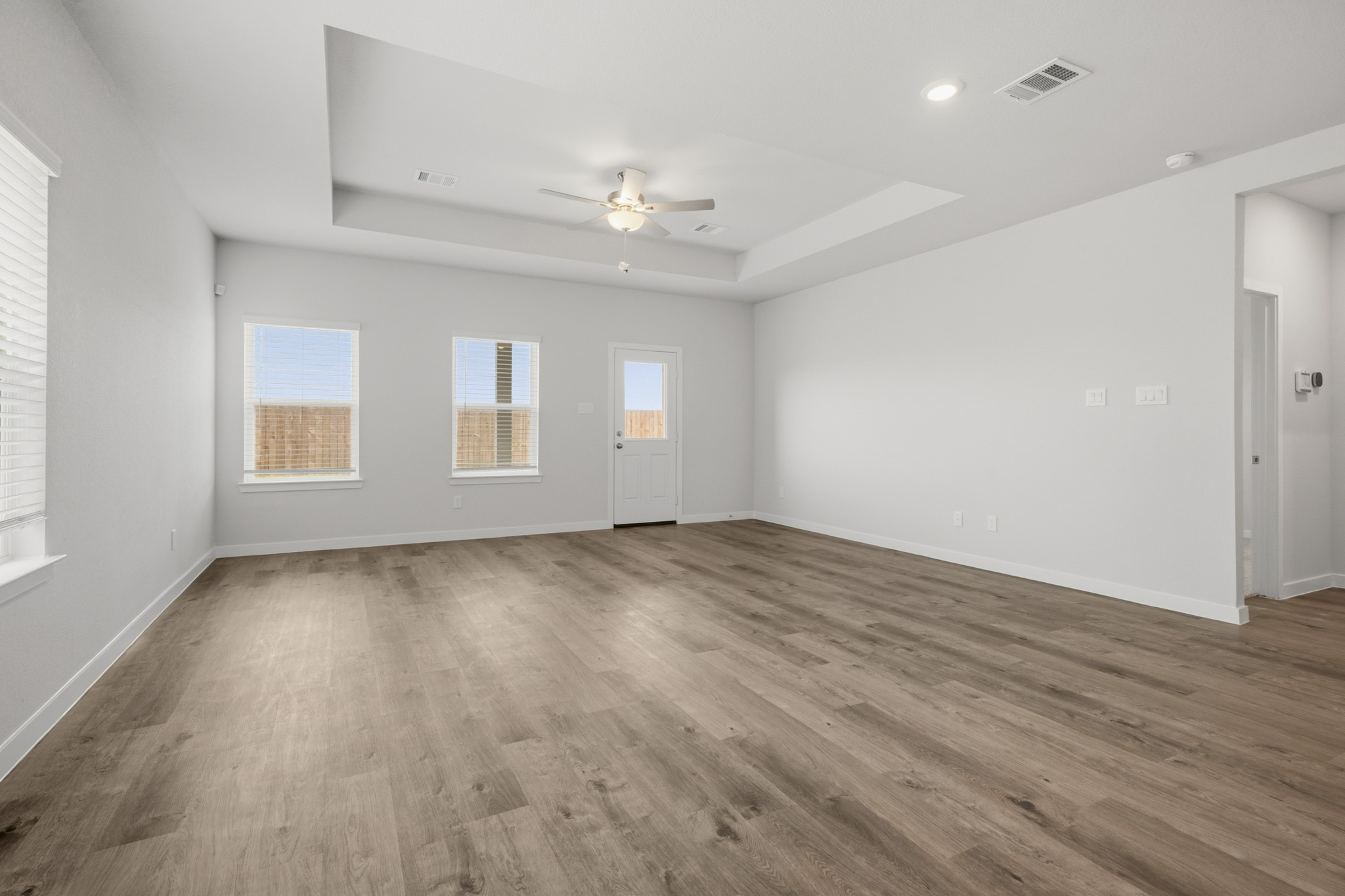 A room with a wood floor and a ceiling fan.