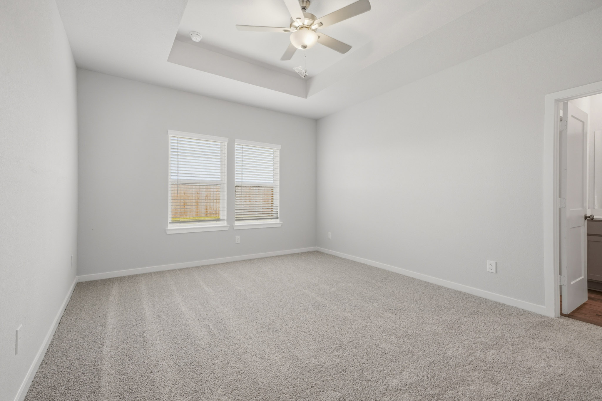 A room with a ceiling fan and a window.