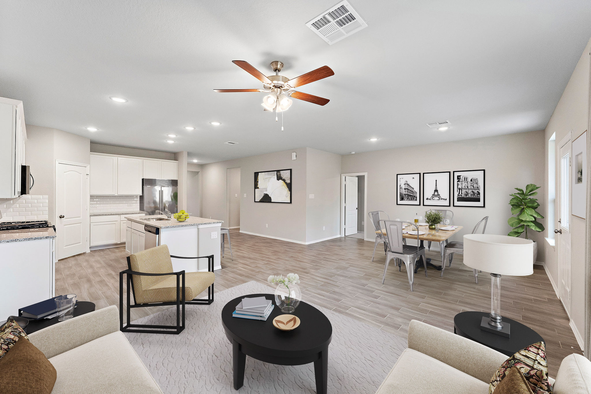 A large living room with a ceiling fan and a table.