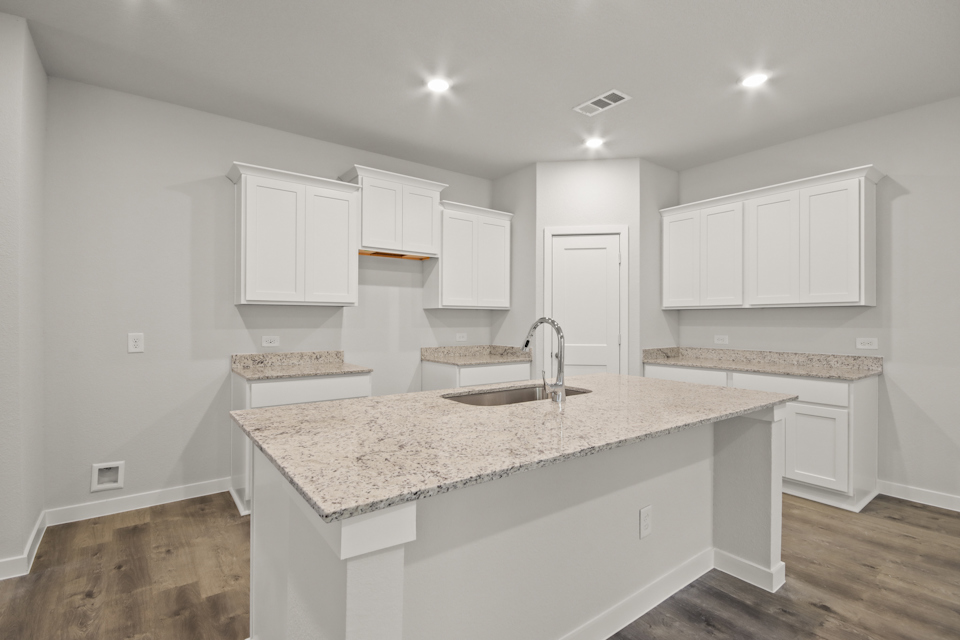 A kitchen with white cabinets.