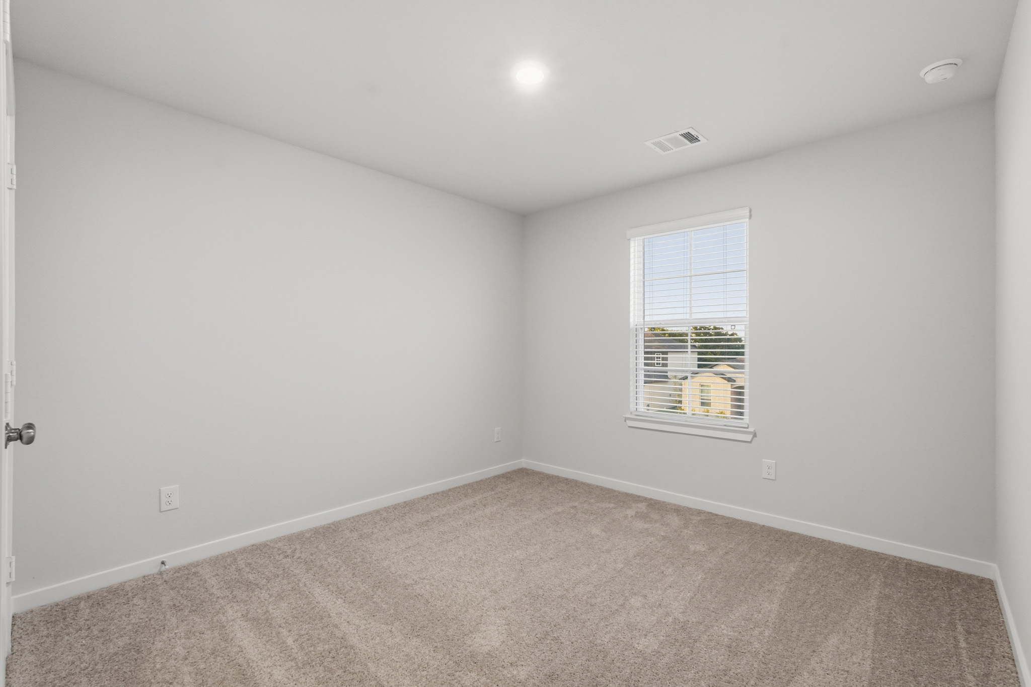A room with a carpet and a window.