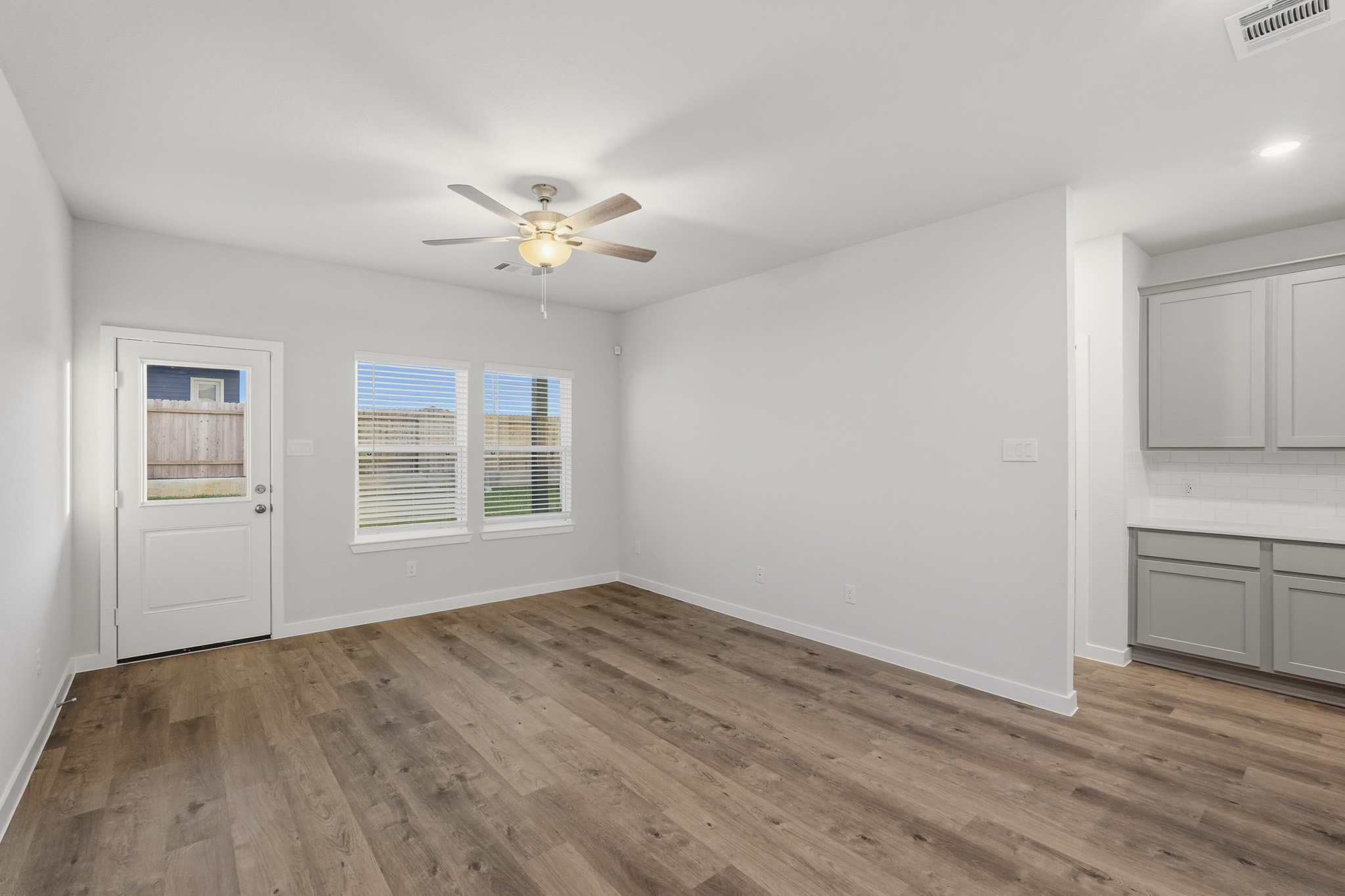 A room with a wood floor and a ceiling fan.