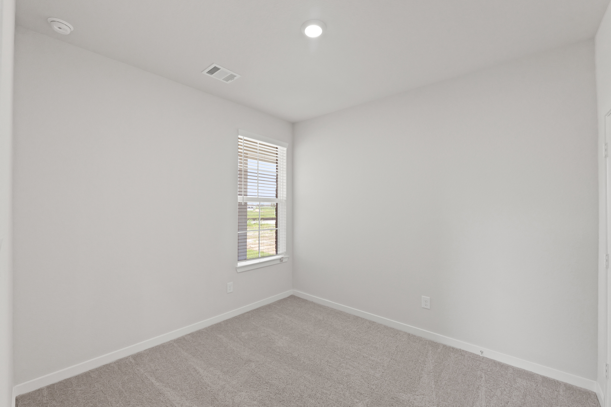 A room with a window and a carpet.