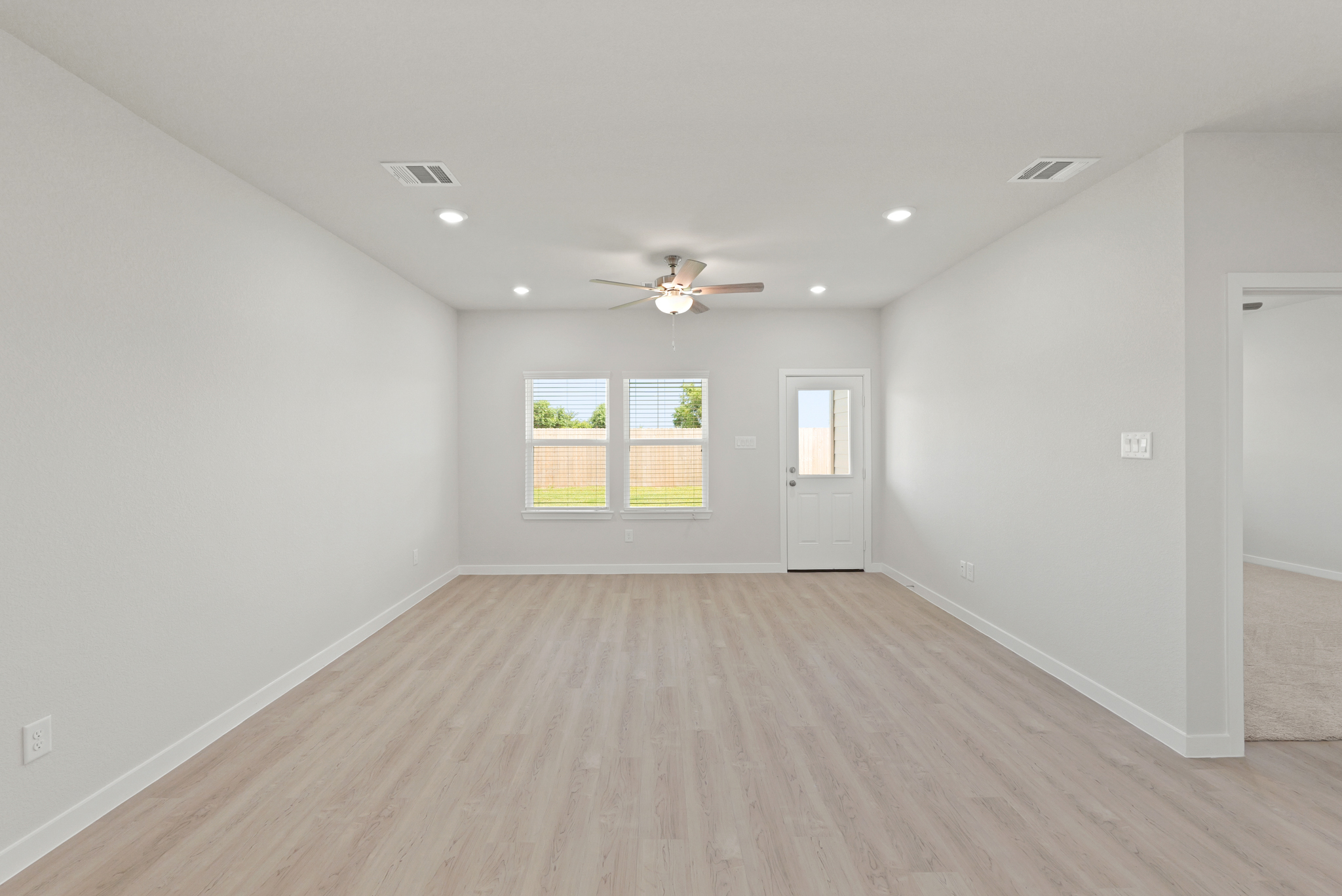 A room with a wood floor and a ceiling fan.