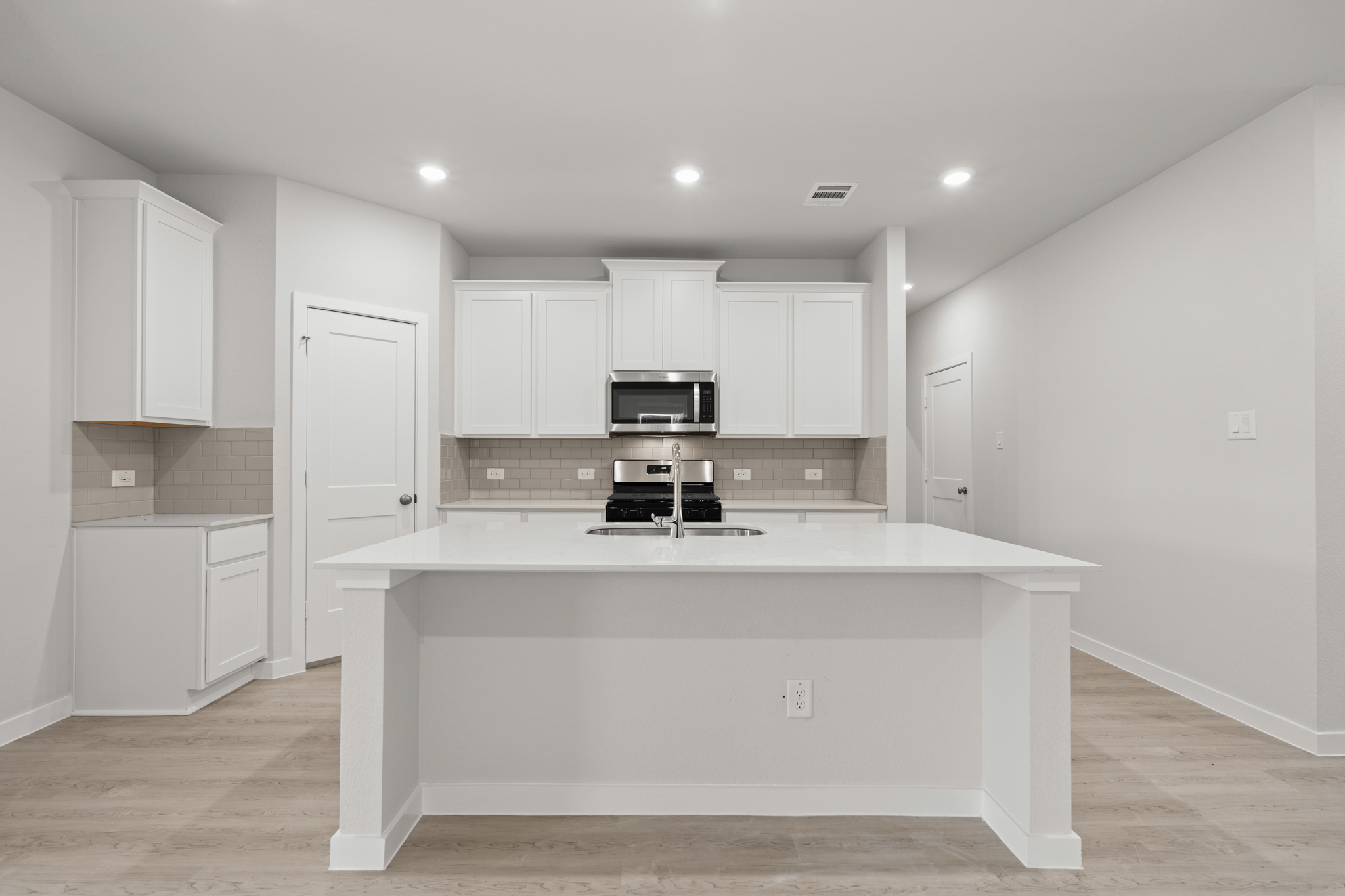A kitchen with white cabinets.