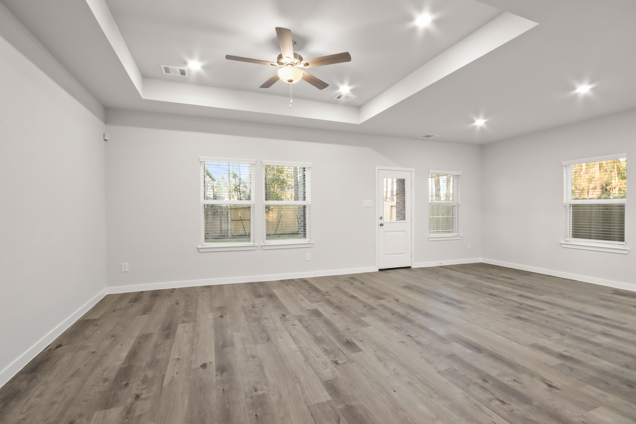 A room with a wood floor and a ceiling fan.