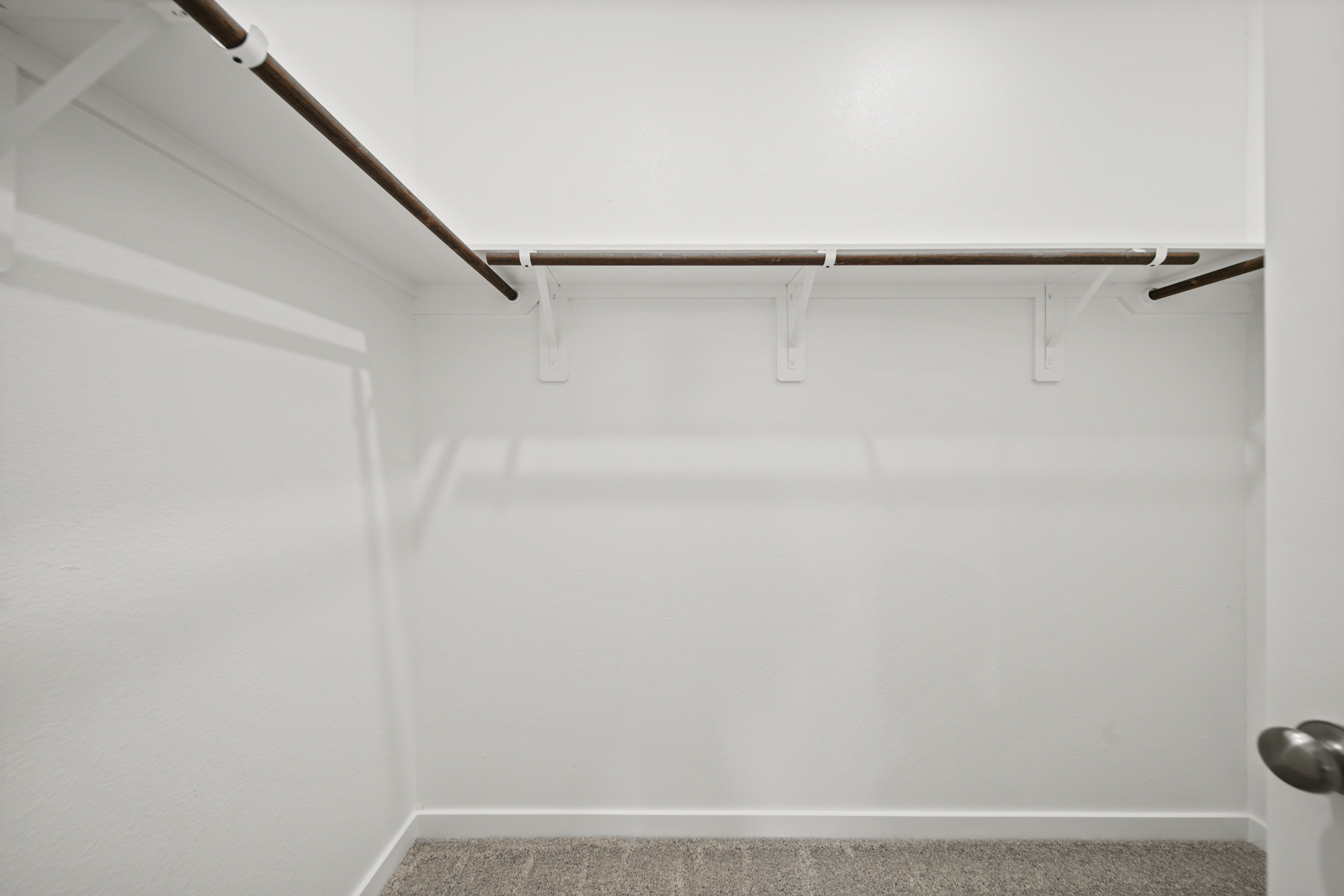 A white wall with a metal bar.