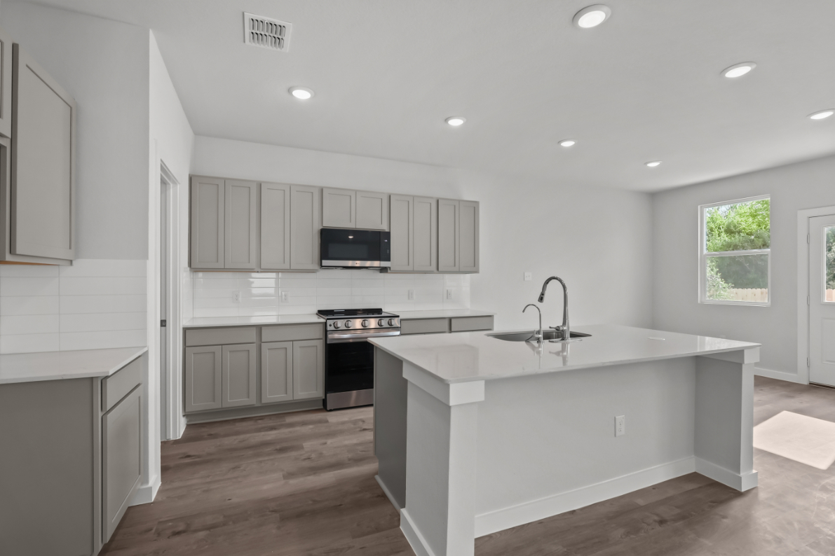 A kitchen with white cabinets.