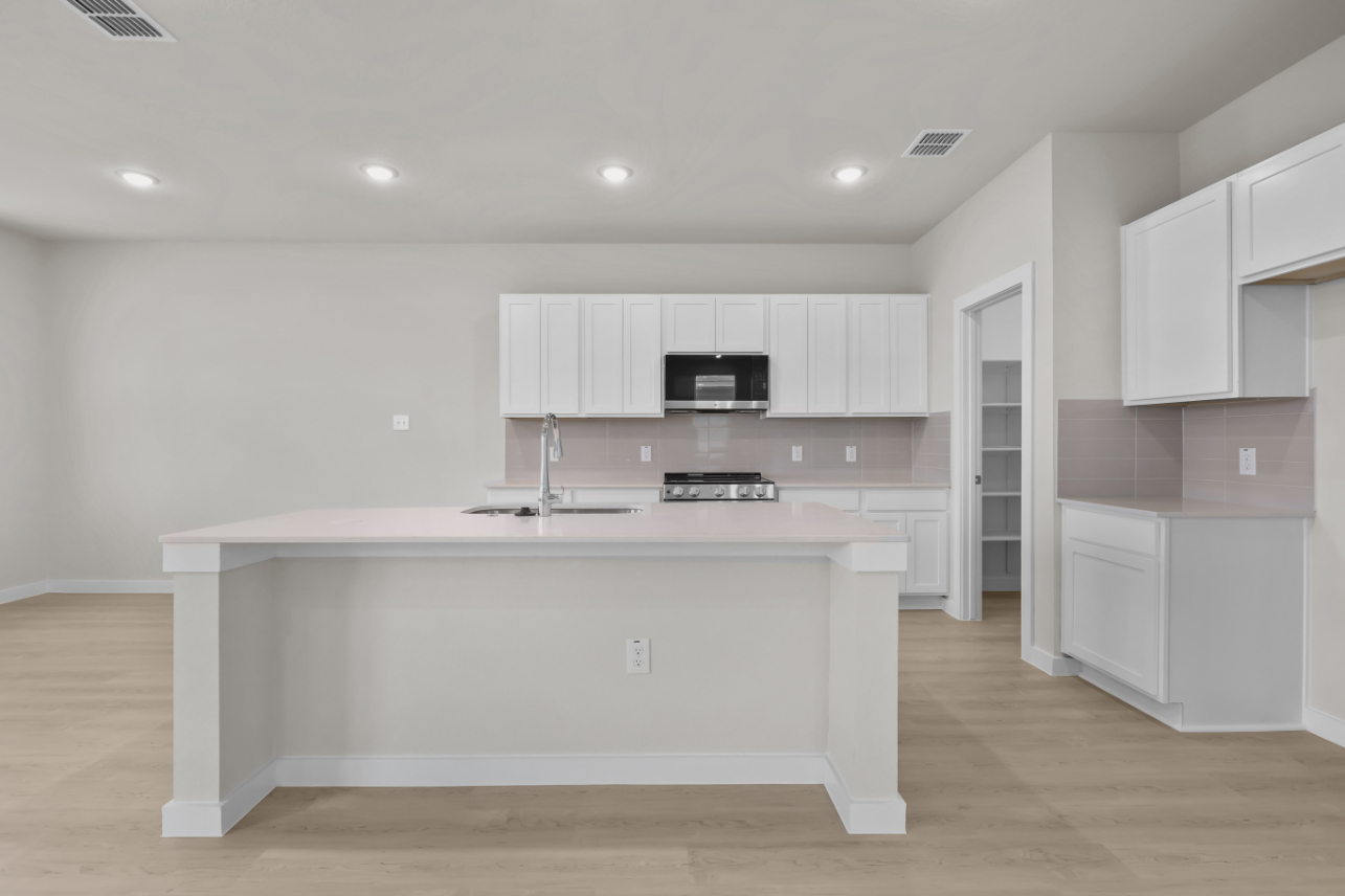 A kitchen with white cabinets.