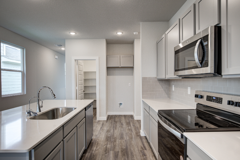 A kitchen with white cabinets.