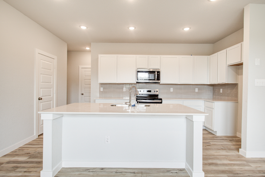 A kitchen with white cabinets.