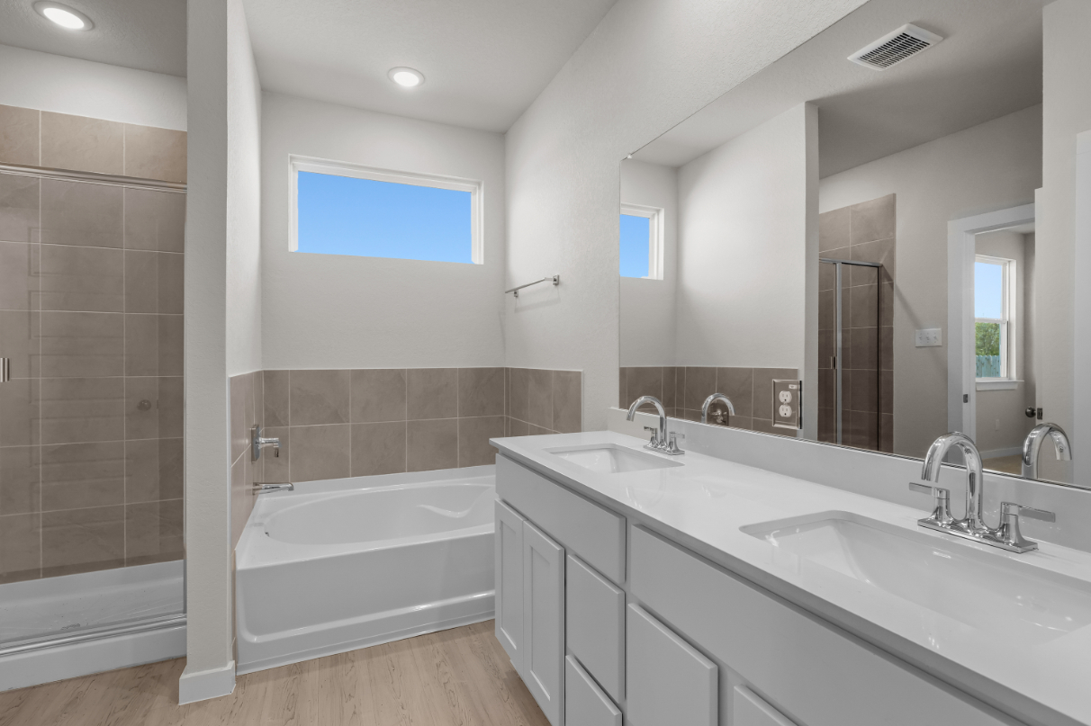 A bathroom with a tub sink and a mirror.