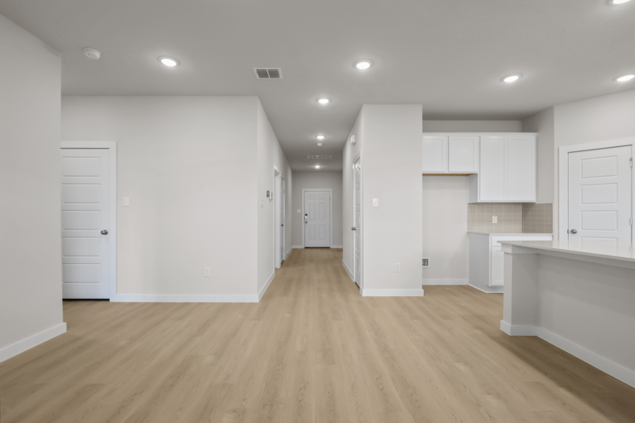 A large empty room with white cabinets.