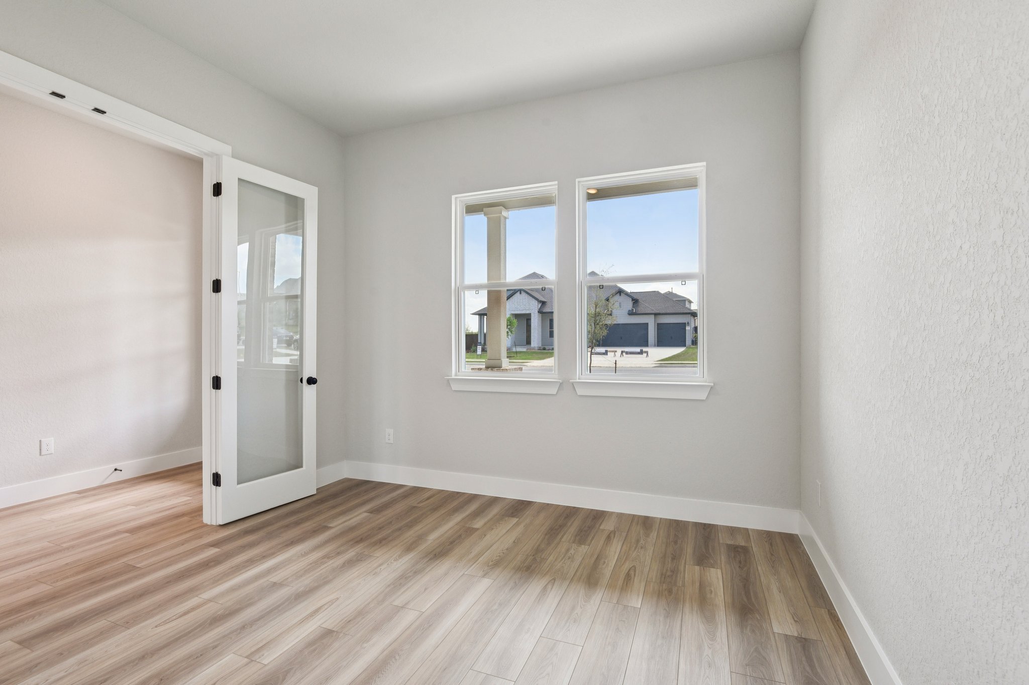 A room with a wood floor and a window.