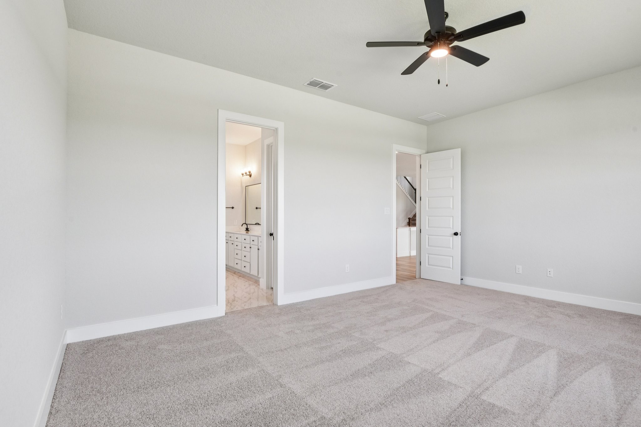 A room with a ceiling fan and a door.