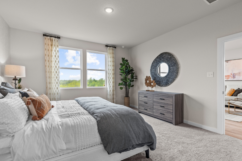 A bedroom with a bed and a mirror.