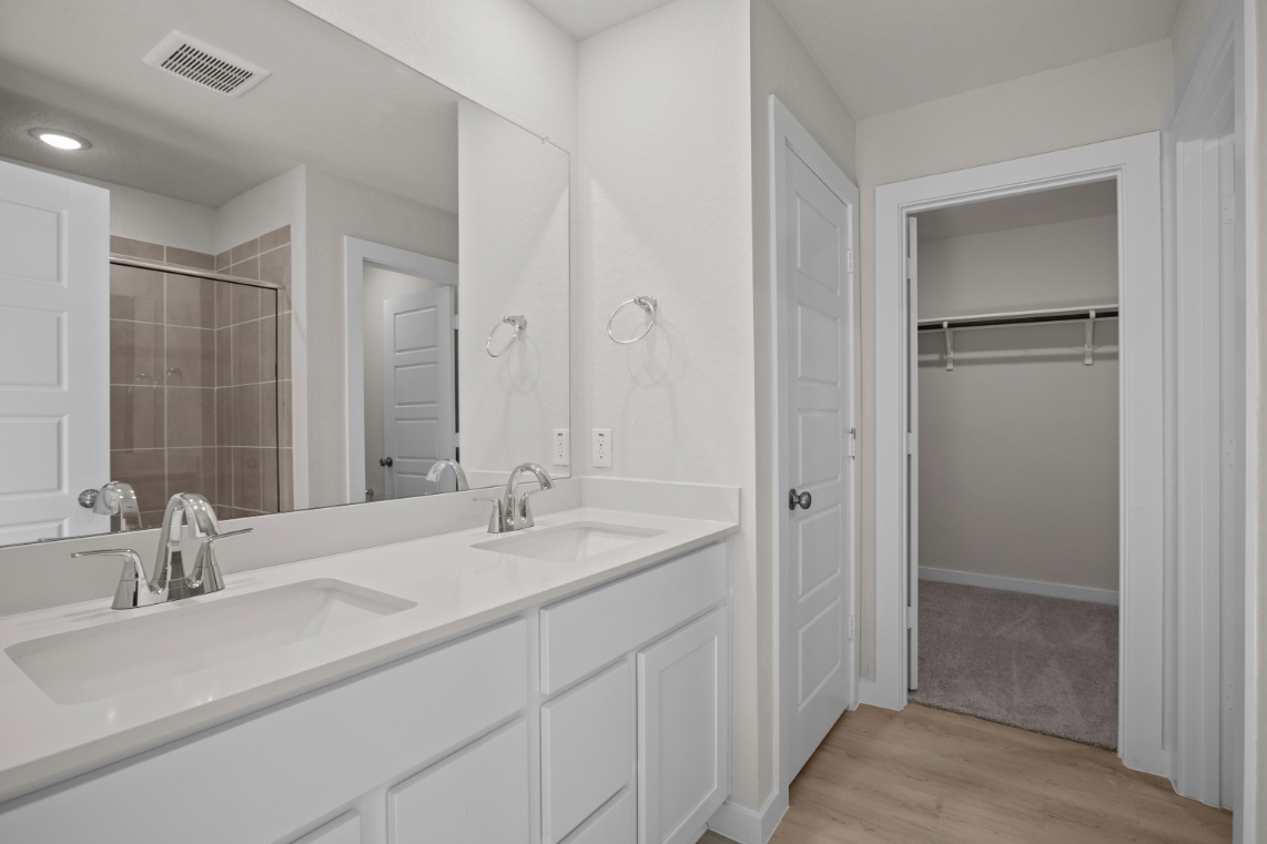A bathroom with white cabinets.