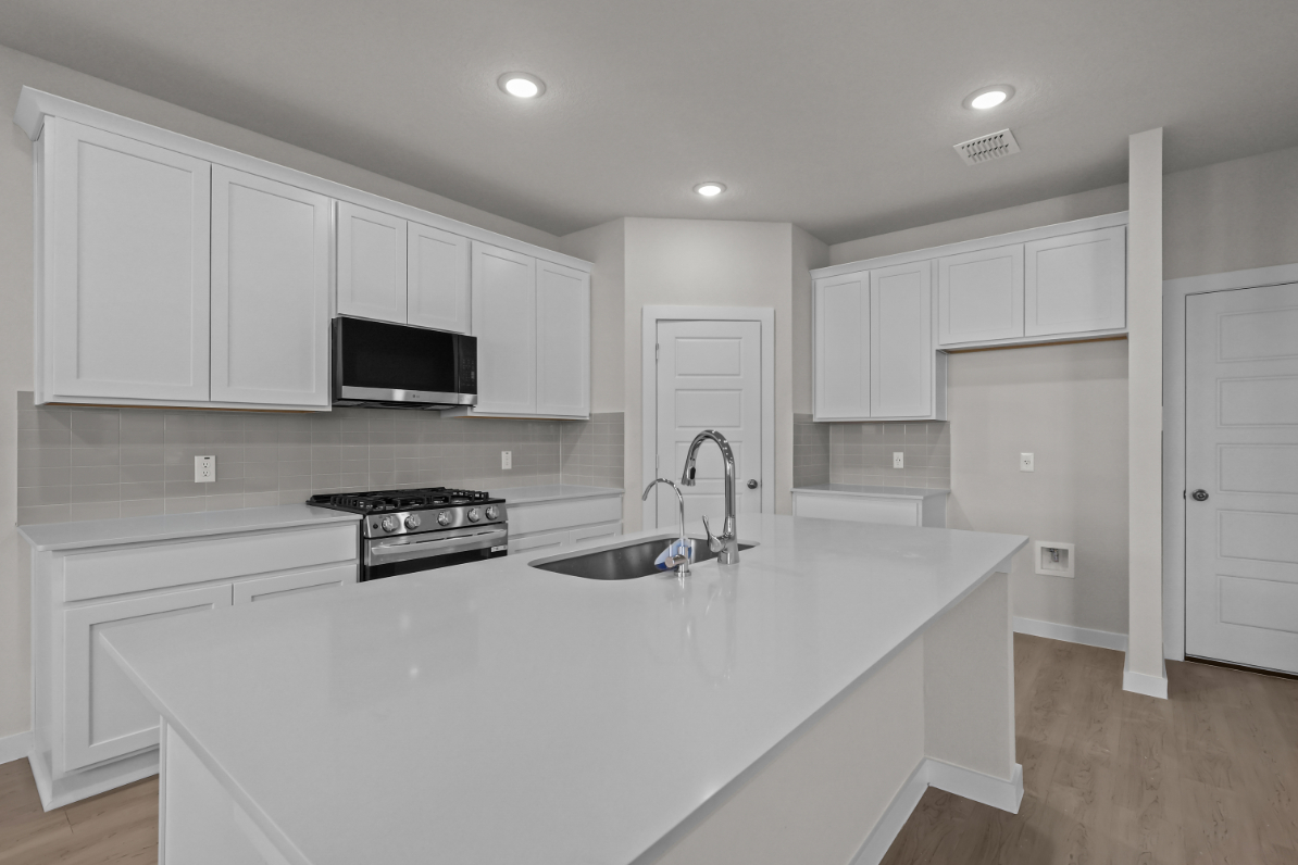 A kitchen with white cabinets.