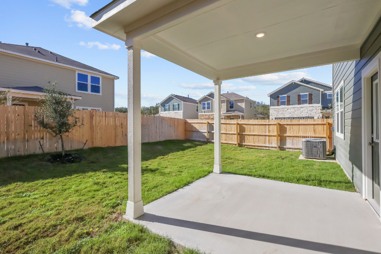 A backyard with a fence and a house.