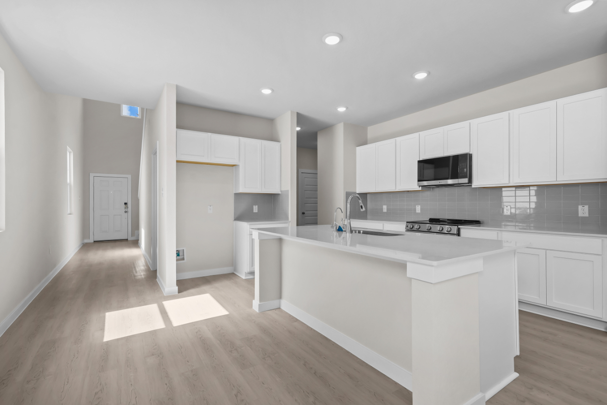 A kitchen with white cabinets.